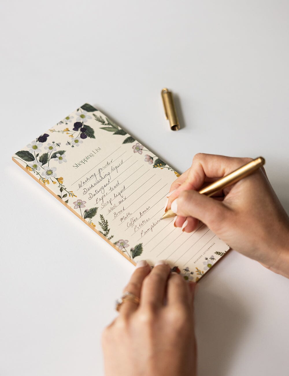 Cockatoo Shopping List DL Fridge Notepad with botanical and bird illustrations, gold foil bellyband, and lined tear-off pages