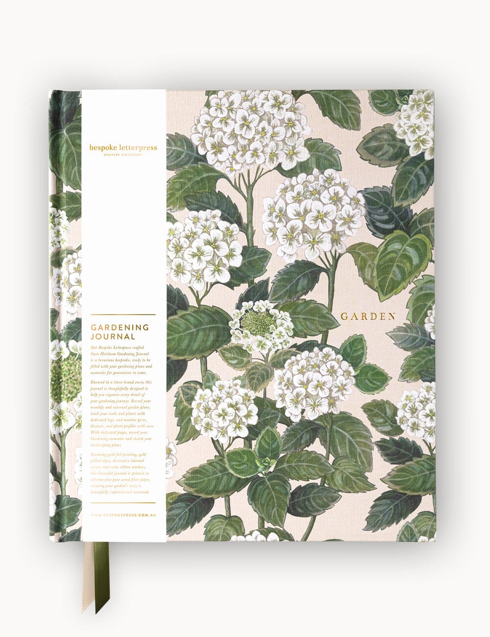 Flat Lay of the Heirloom Gardening Journal Linen Bound Journal with delicate Hydrangea cover design in soft peach, cream, and olive tones, wrapped with a branded belly band featuring gold foil details.