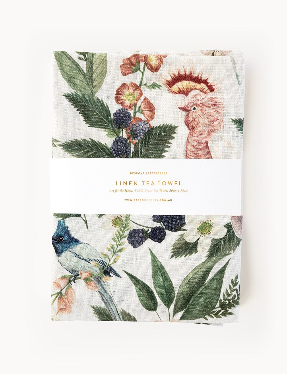 Pink Cockatoo linen tea towel folded in packaging, featuring botanical illustrations of native birds, blackberries, and wildflowers on 100% linen