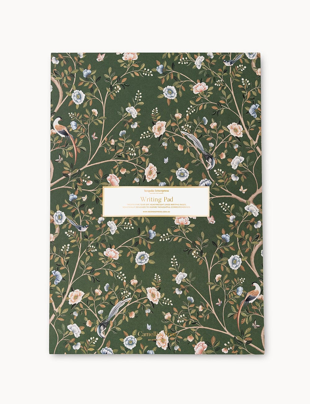 Flat lay of the Bespoke Letterpress Camellia Tree A4 Writing Pad, featuring an elegant deep green cover adorned with intricate camellia blossoms, delicate birds, and soft pink and blue floral accents.